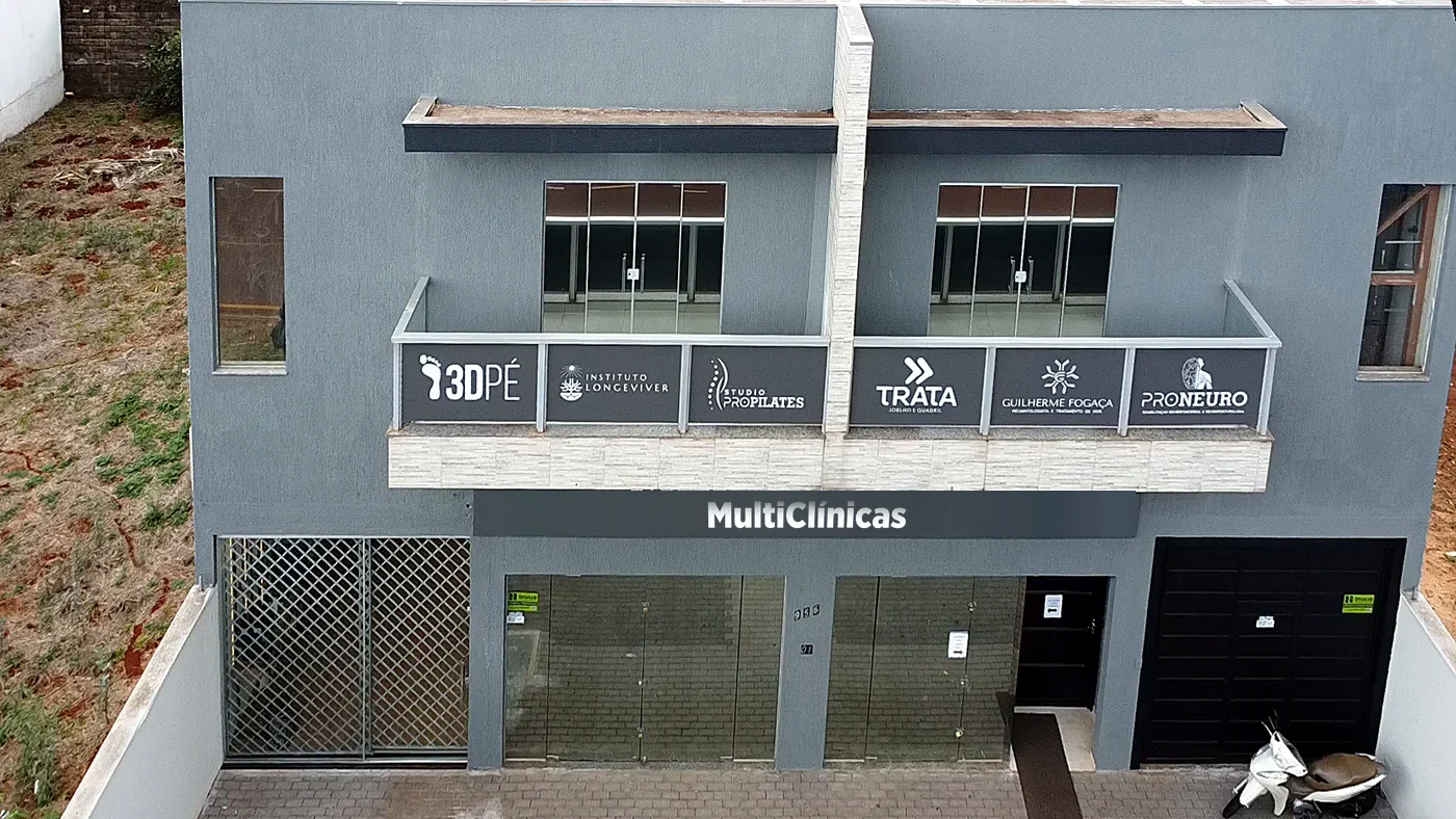 Fachada do prédio da Multiclínica vista de frente, com as placas das clínicas na sacada